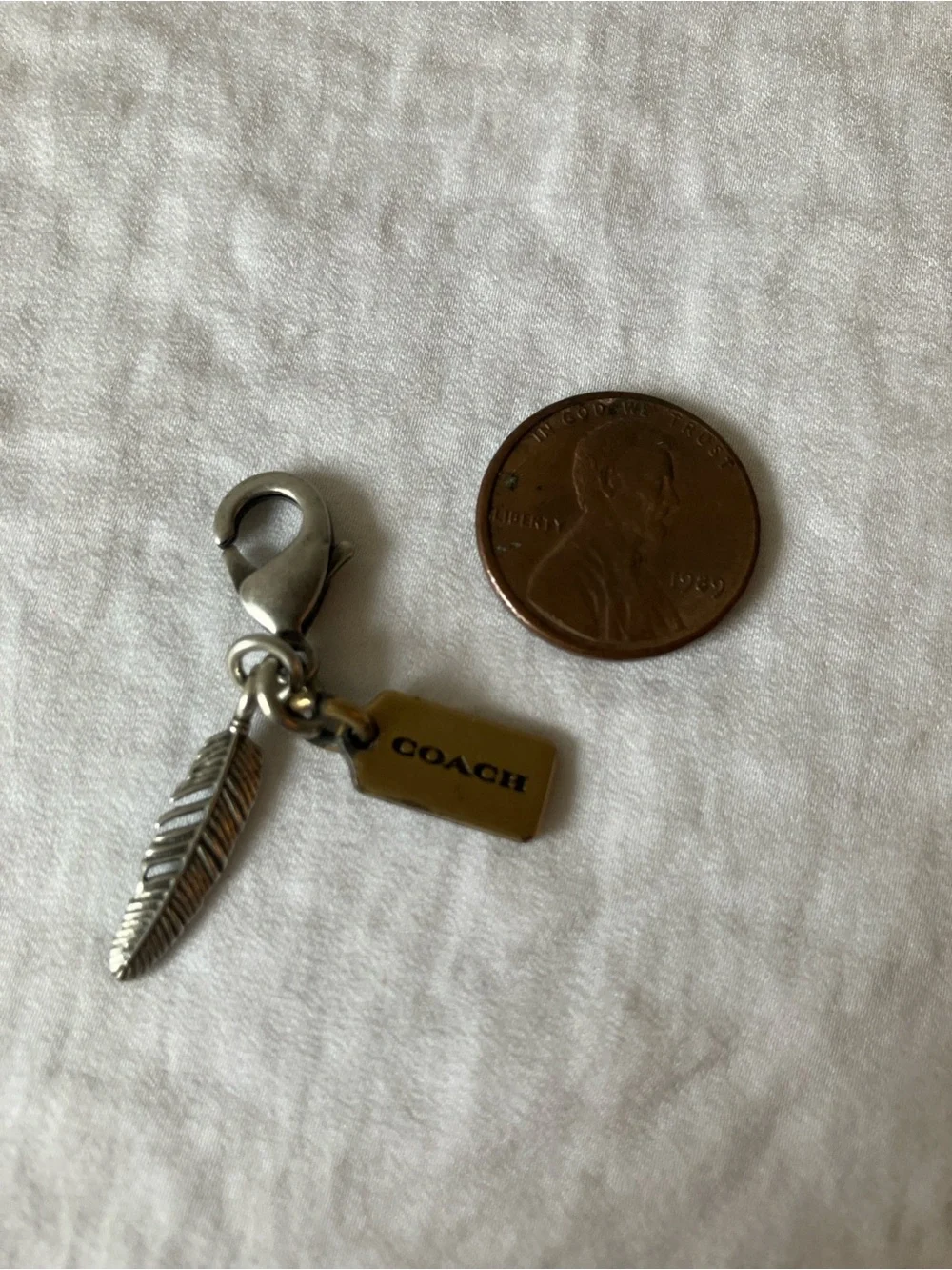 Coach: Silver Tone & Gold Tone Feather Charm Keyring